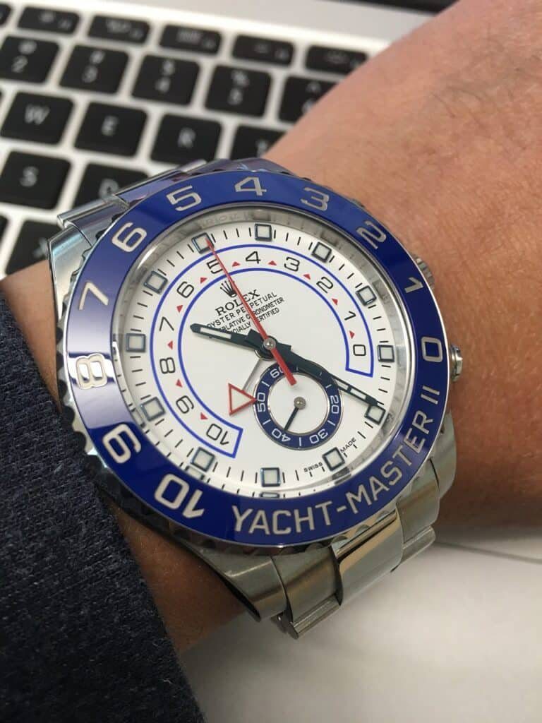 A picture of Rolex Yatch-Master with blue bezel and white dial, on a man's wrist watch